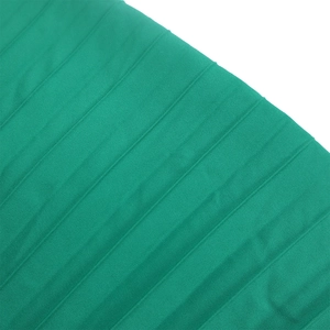 Macro view of emerald green pleated fabric with delicate vertical folds and satin finish