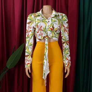 Detail of tropical palm leaf print shirt with front tie-waist and long sleeves