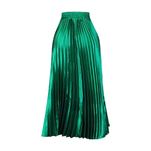 Détail d'une jupe longue plissée vert émeraude avec éclat métallique et taille élastique