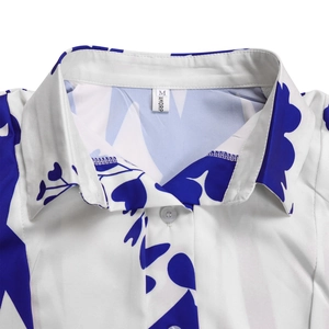 Detail of white shirt collar with navy floral print and polished button on textured fabric