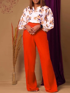 Ensemble femme avec chemise à manches longues fleurie et pantalon orange à jambes larges