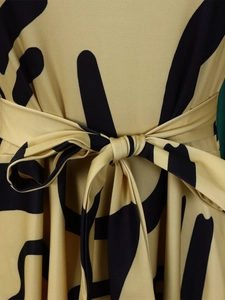 Detail of waist tie and black geometric print on yellow African plus size midi dress