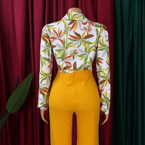 Detail of tropical floral shirt back and high-waisted yellow pants on a mannequin