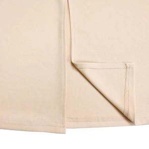 Detailed close-up of the split hem and professional stitching on an apricot knit dress