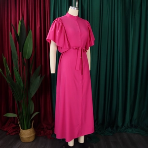Detail of rose red dress featuring flared sleeves, button-front design, and matching belt