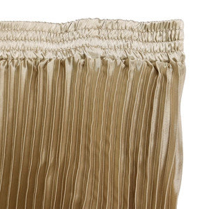 Détail de la jupe plissée champagne avec taille élastique et texture satinée brillante