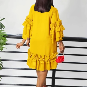 Detail of yellow chiffon dress back featuring layered ruffles and pearl decorations
