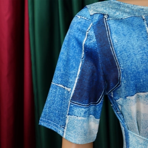 Détail de la manche courte et de la couture d'épaule d'une robe maxi à imprimé denim bleu