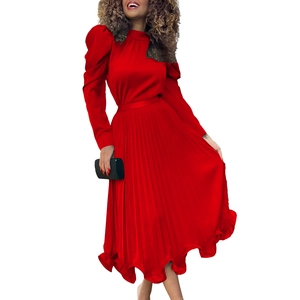 Detail of red mock neck pleated dress featuring elegant puff sleeves and black lace trim