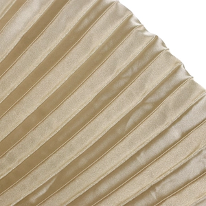 Vue macro du tissu satiné plissé or champagne avec détails de texture brillants