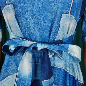 Détail de la ceinture à nouer et de l'imprimé géométrique bleu sur la robe ample