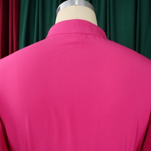 Detail view of the stitching on a rose red button-down dress with a textured matte finish