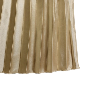 Gros plan détaillé du tissu en satin plissé or champagne avec un éclat métallique