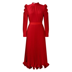 Detail of red high-neck dress with pleated skirt and ruffled hem showing fabric texture