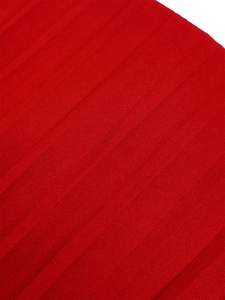 Detailed close-up of red pleated fabric texture showing vertical folds and material grain