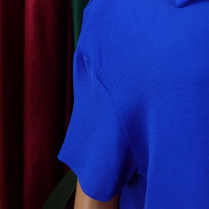 Detail of short sleeves on a royal blue casual shirt with textured fabric surface