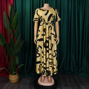 Détail de la robe jaune avec imprimés fluides noirs et ceinture à nouer à la taille