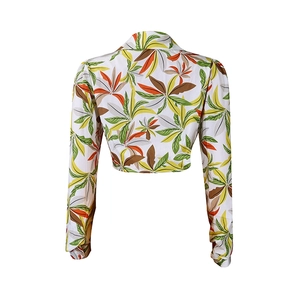 Back view of a cropped long sleeve shirt featuring a vibrant tropical leaf print pattern