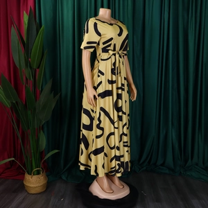 Détail de la robe jaune à manches courtes avec motifs abstraits noirs et ceinture nouée
