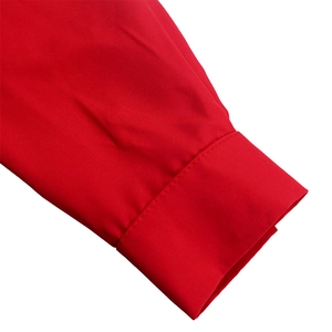 Close-up of bright red blouse sleeve showing smooth plain weave and fine stitching details