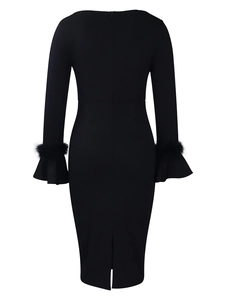 Détail de la robe moulante noire avec des manches évasées ornées de plumes chic