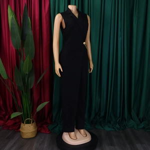 Detail of elegant black sleeveless jumpsuit featuring a blazer lapel and gold chain buckle