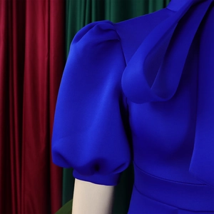 Detail of royal blue puff sleeve dress with elegant shoulder bow for formal party events