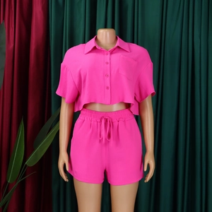 Detail of hot pink casual summer set featuring short sleeve button shirt and drawstring shorts