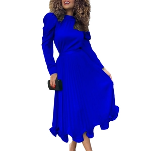 Detail of royal blue pleated skirt set featuring black lace shoulder accents and bell sleeves