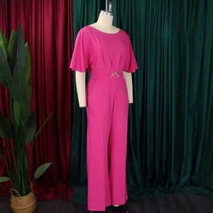 Detail view of the rose pink wide-leg jumpsuit featuring an elegant gold-buckle waist belt