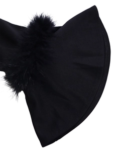 Détail du tissu noir tissé avec bordure en fausse fourrure pelucheuse sur les manches