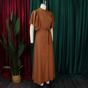 Detail view of brown long dress with flared sleeves, stand collar and button front