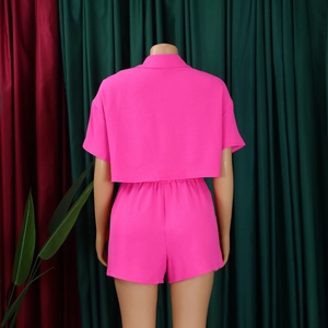 Rear view of neon pink two-piece set featuring short sleeve top and high waist shorts