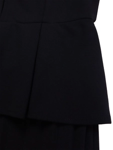 Detailed close-up of the double-layered ruffled hem and high-waisted black pencil dress fabric