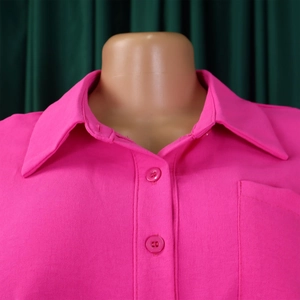 Detail of bright pink lapel shirt featuring matching resin buttons and chest pocket