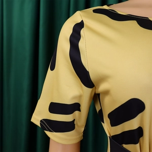 Gros plan du tissu de robe jaune avec rayures noires abstraites et coutures nettes