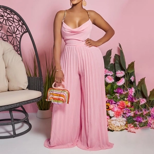 Detail of pink pleated wide-leg jumpsuit with gold chain straps and cowl neckline