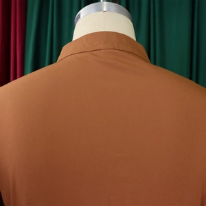 Macro detail of the back tailoring and rust brown fabric texture on the stylish maxi dress