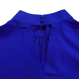 Detail view of bright blue puff sleeve top with high neck and teardrop back cutout