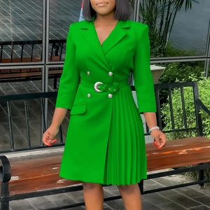 Detail of emerald green pleated blazer dress with double-breasted buttons and belted waist