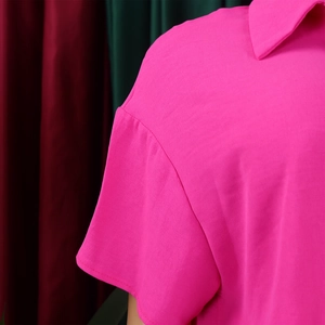 Detail of pink short sleeve shirt featuring dropped shoulder seams and lapel texture