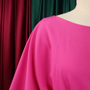 Detail of rose pink wide leg jumpsuit showing dense twill texture and dropped shoulder seams