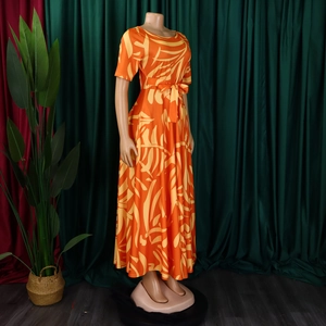 Détail d'une robe longue trapèze orange à imprimé feuilles avec ceinture assortie