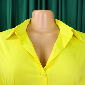 Close-up of vibrant yellow button-down shirt collar and woven fabric detail on a mannequin