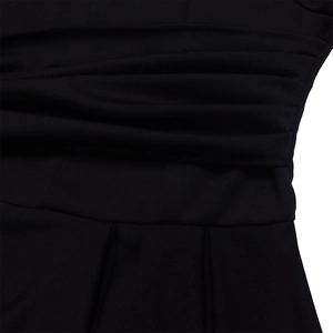 Detailed view of layered horizontal pleats and waist tailoring on a black maxi dress