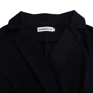 Detail of the elegant notched lapel and fabric texture on a black sleeveless jumpsuit