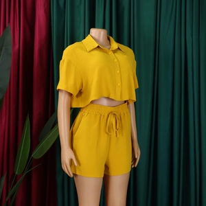 Detail of bright yellow summer two-piece set featuring a collared shirt and drawstring shorts