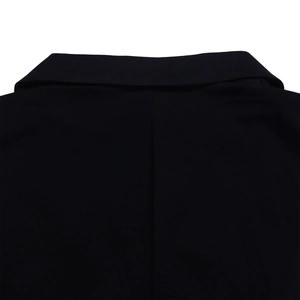 Detailed close-up of the notched lapel and woven texture on a black sleeveless jumpsuit