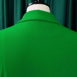 Detail view of the green pleated dress collar with clean stitching on a white mannequin