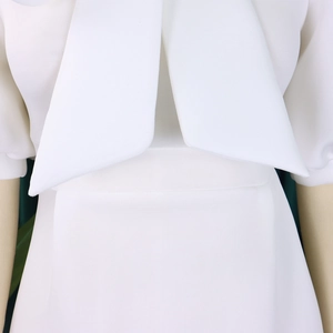 Close-up of elegant double-layered bow detail on the neckline of a white party dress